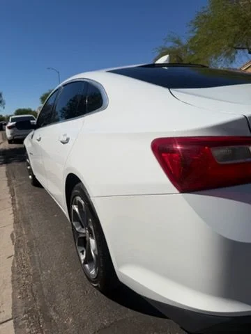 White sedan rear three-quarter view