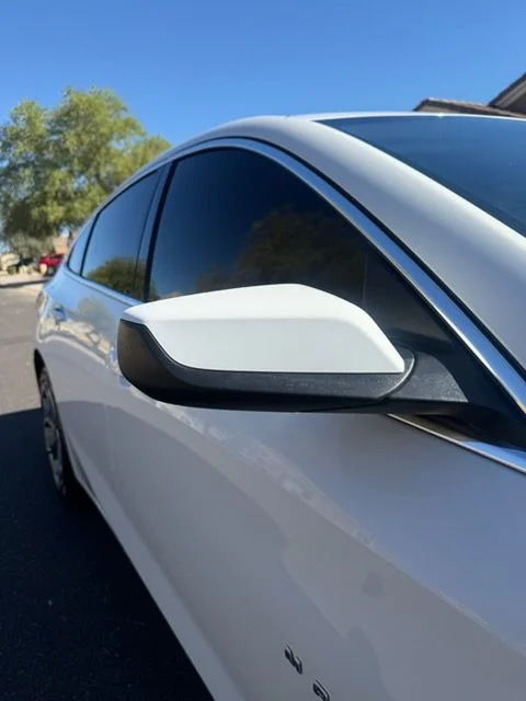 Side mirror on a white sedan